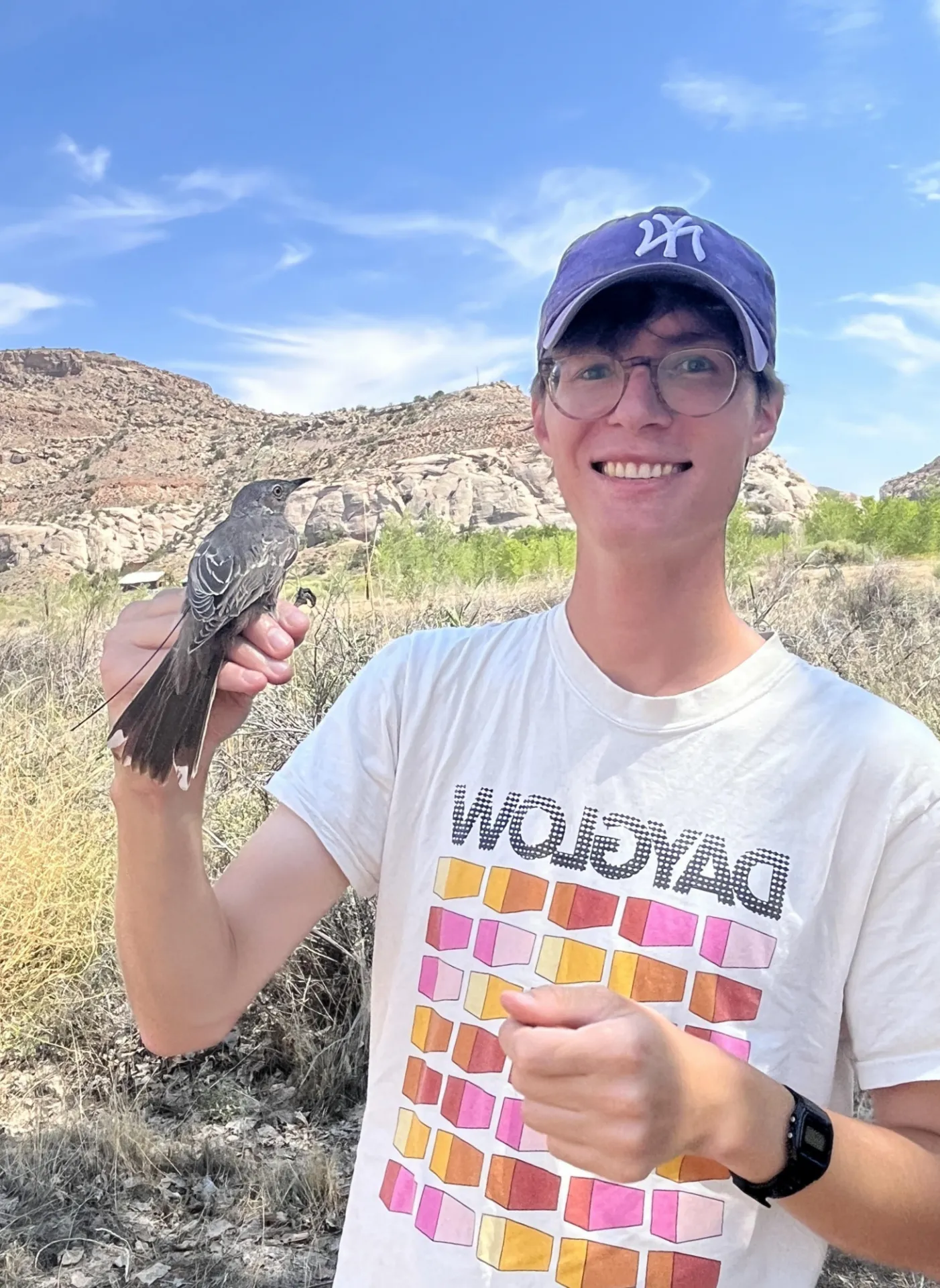 Stephen Mooney holding a bird while conducting field work. 